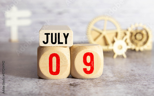 July 9th. Image of july 9 wooden color calendar on blue background. Summer day. Empty space for text