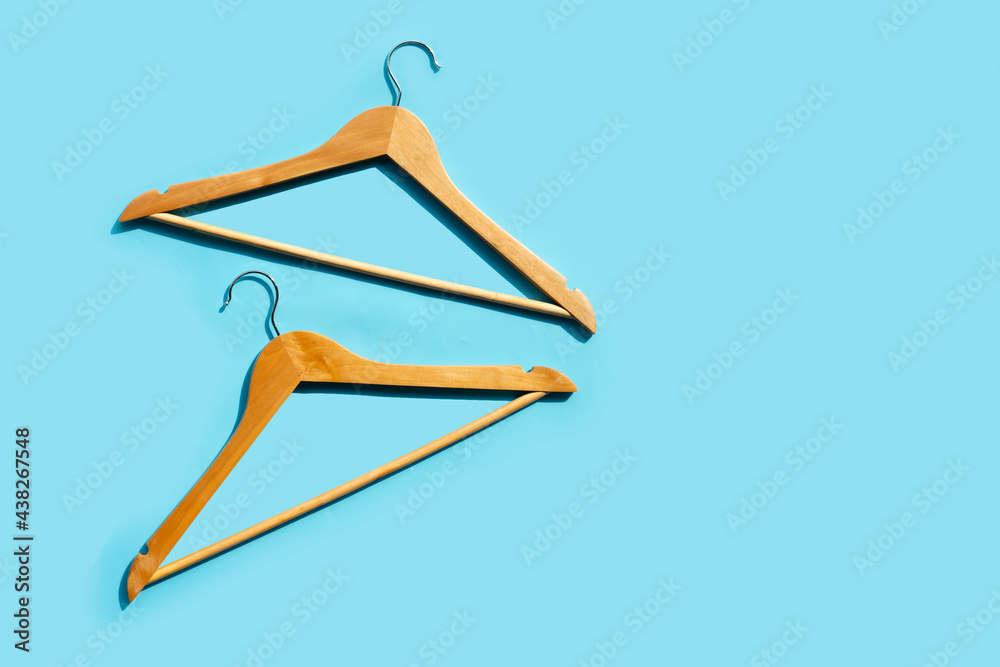 Wooden clothes hangers on blue background Wooden clothes hangers on blue background