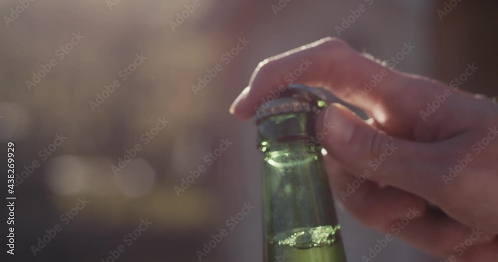Female hand open beer bottle opener summer macro close up slow motion
