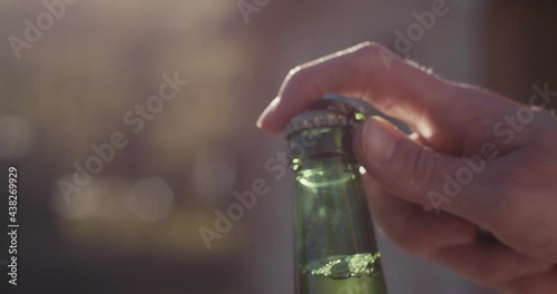 Female hand open beer bottle opener summer macro close up slow motion