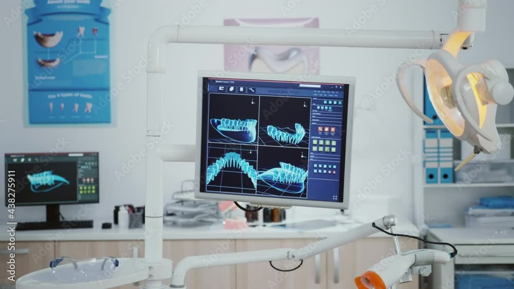 Closeup of monitor with tooth radiography images on it inside empty orthodontist stomatology hospital office room with nobody in it. Dental cabinet with medical tools prepared for healthcare treatment Closeup of monitor with tooth radiography images on it inside empty orthodontist stomatology hospital office room with nobody in it. Dental cabinet with medical tools prepared for healthcare treatment
