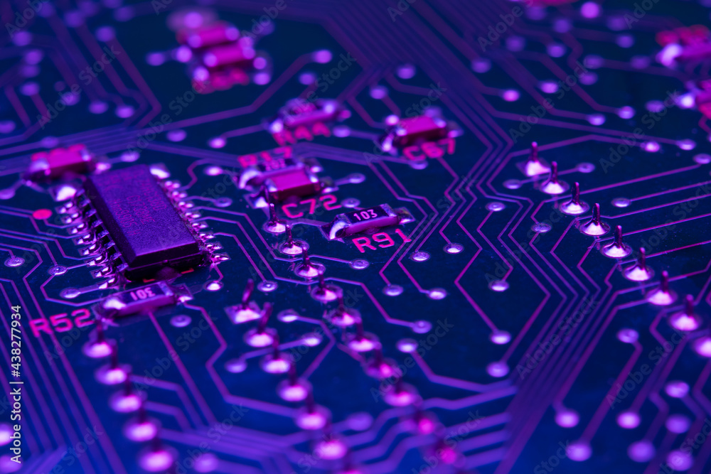 Electronic circuit board components chips resistors illuminated with neon light Electronic circuit board components chips resistors illuminated with neon light
