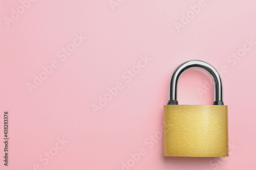 Modern padlock on pink background, top view. Space for text