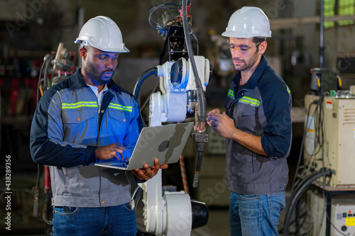 Two Industry engineers stand and discussion work in the factory workshop.
