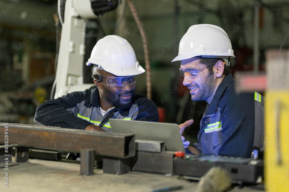 Two Industry engineers sitting and discussion work in the factory workshop. Two Industry engineers sitting and discussion work in the factory workshop.