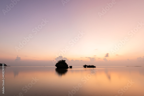 Gorgeous long exposure sunset. Smooth sea surface, islets in silhouette, pastel colors sky mirrored on the ocean. Iriomote Island. © Renata Barbarino