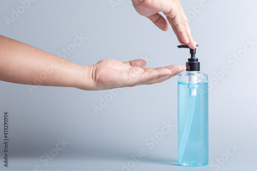 Person's hand pushing pump bottle of sanitizer