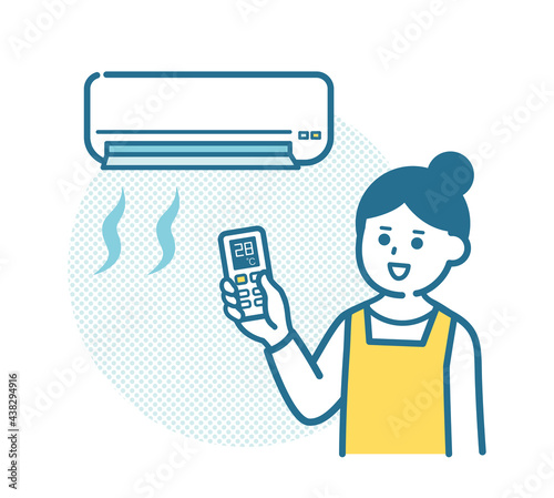 Housewife adjusting the temperature of the air conditioner