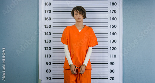 Fotografering Arrested woman posing in an orange suit for a mugshot