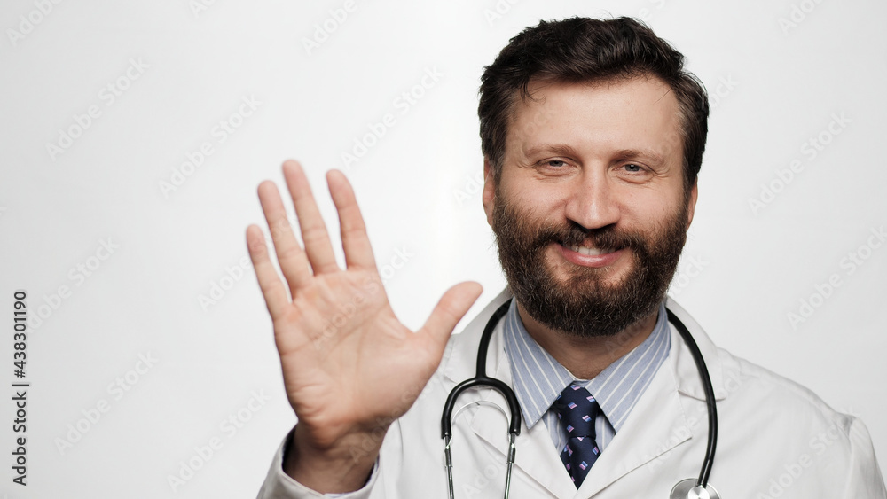 Doctor HELLO. Positive smiling laughing man doctor on white background looking at camera and waving right hand showing HI Doctor HELLO. Positive smiling laughing man doctor on white background looking at camera and waving right hand showing HI
