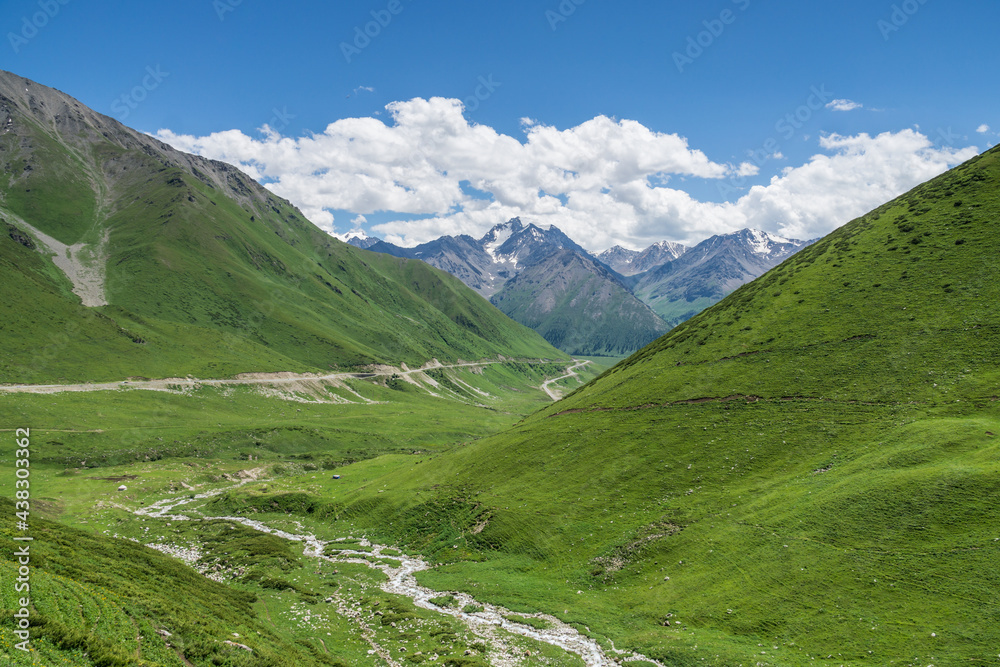 Mountains and grasslands along G217 highway in Xinjiang, China in summer Mountains and grasslands along G217 highway in Xinjiang, China in summer
