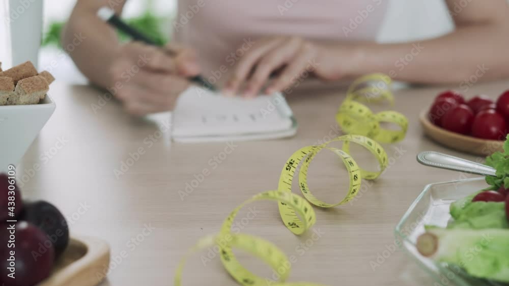 Women taking notes planning healthy menu. Women choosing foods that are healthy such as fruits and vegetables. The concept of healthy eating choices and diet Women taking notes planning healthy menu. Women choosing foods that are healthy such as fruits and vegetables. The concept of healthy eating choices and diet