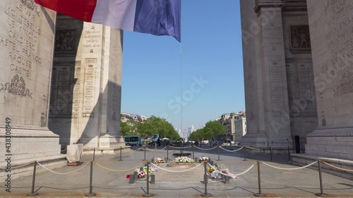 Tilt over the Tomb of the Unknown Soldier and the French Flag waving under the Arc de Triomphe - Paris, France