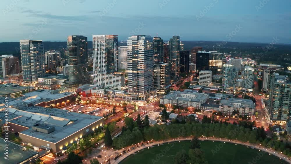 Cinematic trucking 4K aerial drone night shot of the city center of Bellevue, Downtown Park, Bellevue Square, illuminated skyscrapers, tall office and apartment buildings during blue hour after sunset Cinematic trucking 4K aerial drone night shot of the city center of Bellevue, Downtown Park, Bellevue Square, illuminated skyscrapers, tall office and apartment buildings during blue hour after sunset