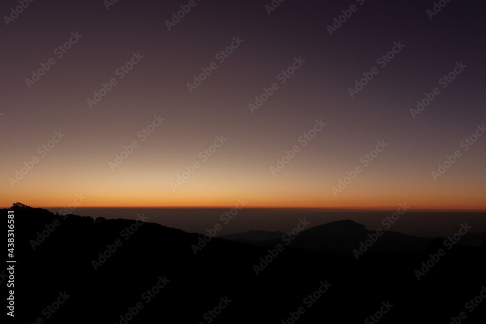Obraz premium Rays of the orange sunshine on the top of the mountain