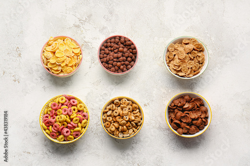 Bowls with different cereals on light background