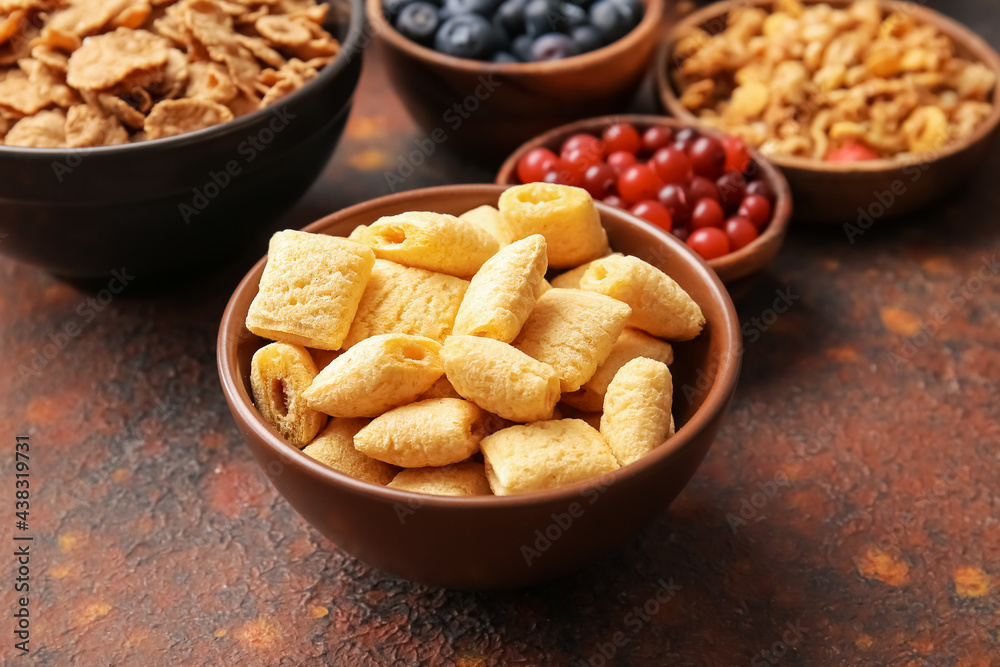 Bowls with different cereals and berries on grunge background, closeup Bowls with different cereals and berries on grunge background, closeup