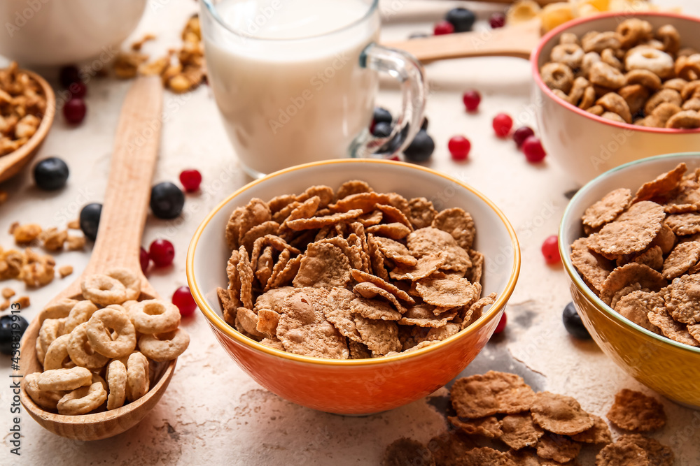 Composition with different cereals, milk and berries on light background, closeup Composition with different cereals, milk and berries on light background, closeup