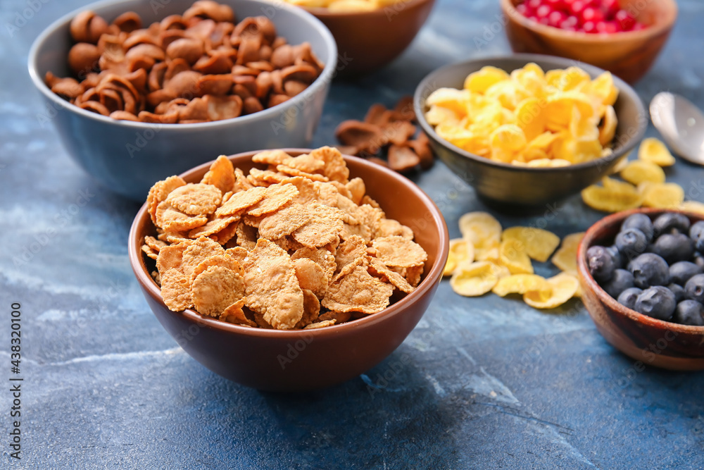 Bowls with different cereals and berries on color background, closeup Bowls with different cereals and berries on color background, closeup
