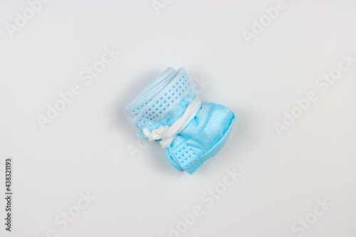 example of folded three ply medical surgical face mask before dispose or throw it away. isolated on white background.