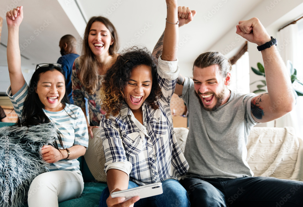 Group of diverse friends playing game on mobile phone Stock Photo