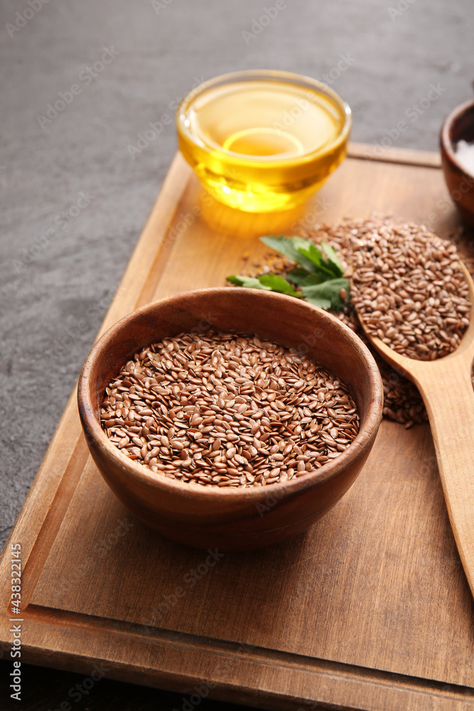 Board with flax seeds and oil on dark background Board with flax seeds and oil on dark background