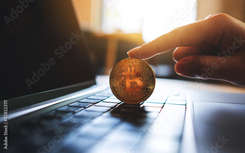 People holding and showing bitcoin on laptop computer photo