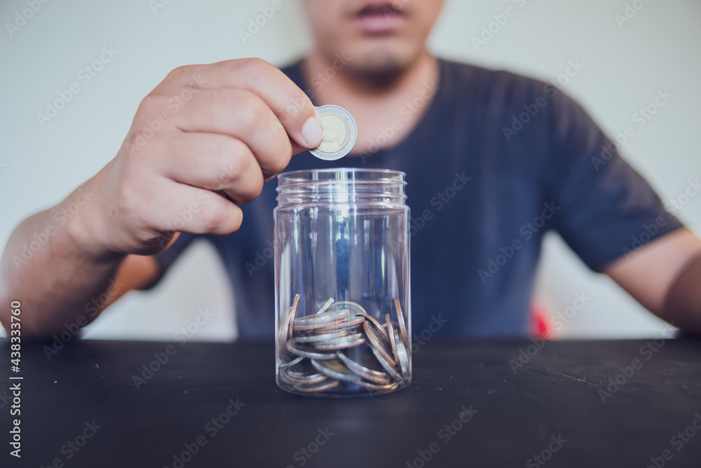 Man holding coins putting in glass, saving money for finance accounting concept. Man holding coins putting in glass, saving money for finance accounting concept.
