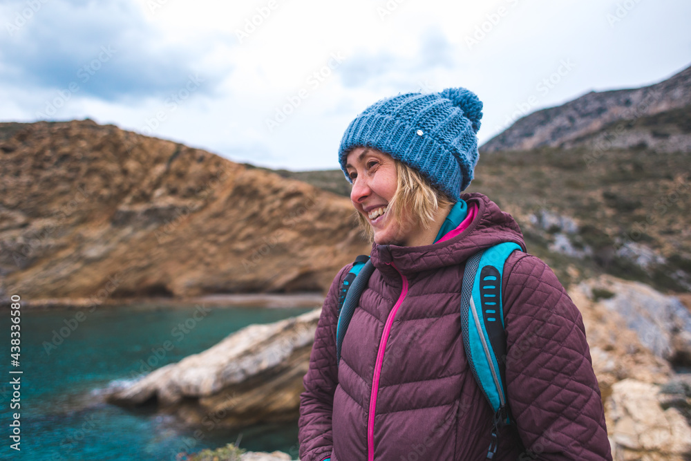 Portrait of a smiling girl in a knitted hat while walking along the sea coast