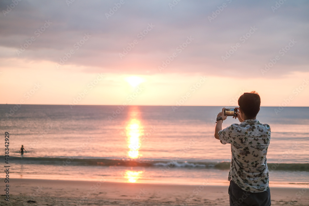 Vacation and technology. Young man using smartphone on sand beach. travel concept