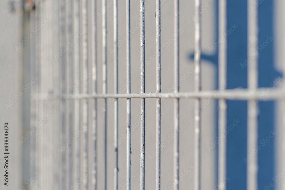 Gray metal vertical stripes fence. Abstract gray background. Close-up. Gray metal vertical stripes fence. Abstract gray background. Close-up.
