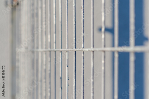 Gray metal vertical stripes fence. Abstract gray background. Close-up.