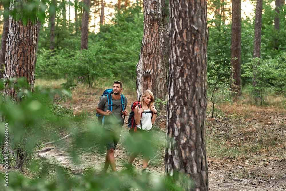 Happy young caucasian couple walking in summer forest Happy young caucasian couple walking in summer forest