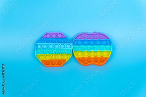 colorful silicon antistress sensory toy fidget push pop it on blue background