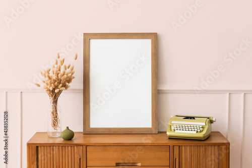 Schilderij op canvas Picture frame on a wooden sideboard table