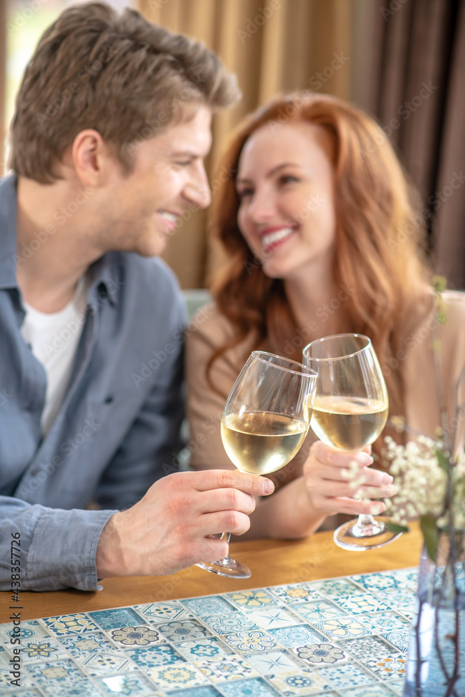 Man and woman touching glasses with each other Man and woman touching glasses with each other