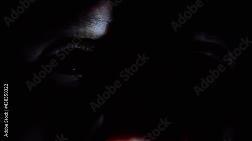 Close up mysterious eye in the night with chiaroscuro, freezing and frightening atmosphere, creepy man's face hidden in the dark, spy eye  photo