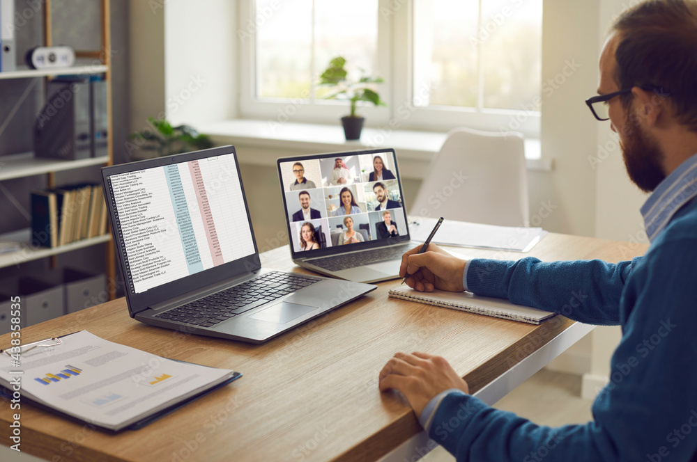 Corporate team manager sitting at table with two laptop computers having  online conference with employees and coworkers. Virtual meetings, remote  teamwork, telework and business management concepts Stock Photo | Adobe  Stock
