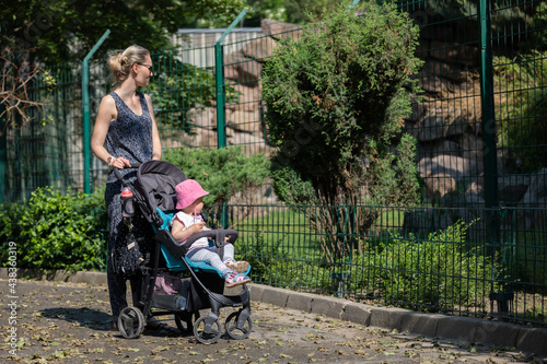 Mutter schaut sich mit ihrem Kind die Tiere im Zoo an photo