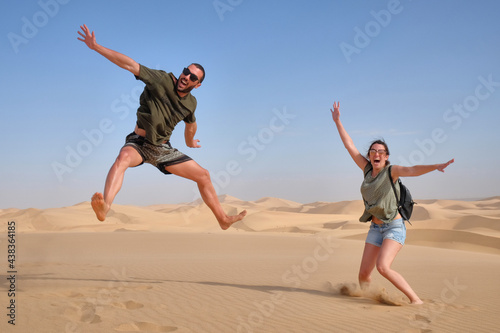 happy couple jumping in the desert