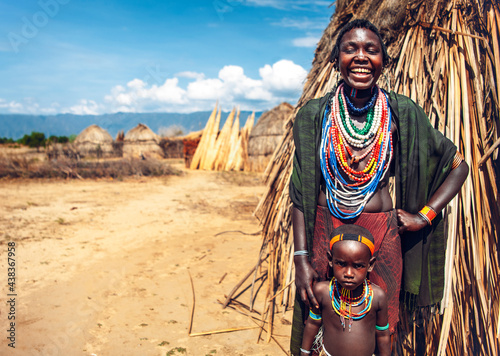 Woman in traditional clothes smiling and with her boy in Arbore photo