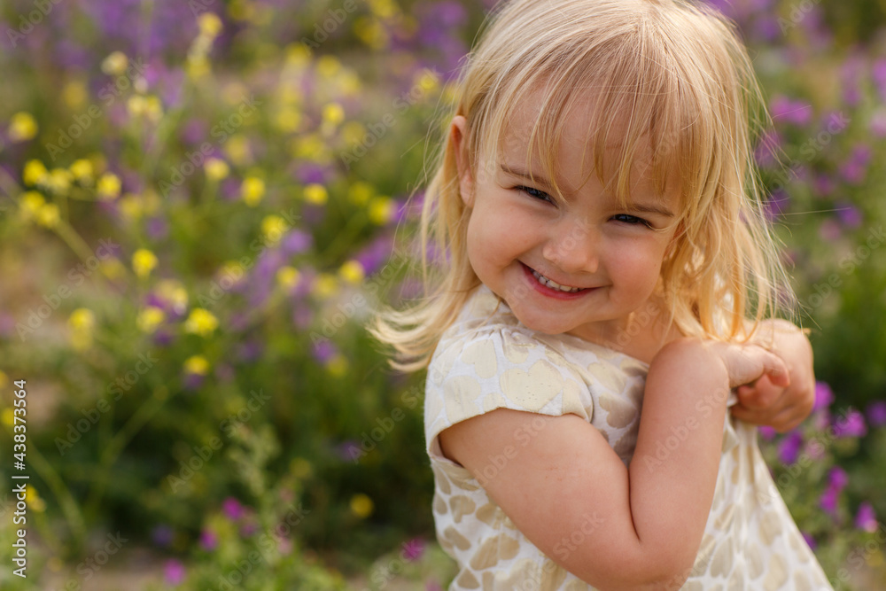 little beautiful girl looking at camera in nature with flowers little beautiful girl looking at camera in nature with flowers