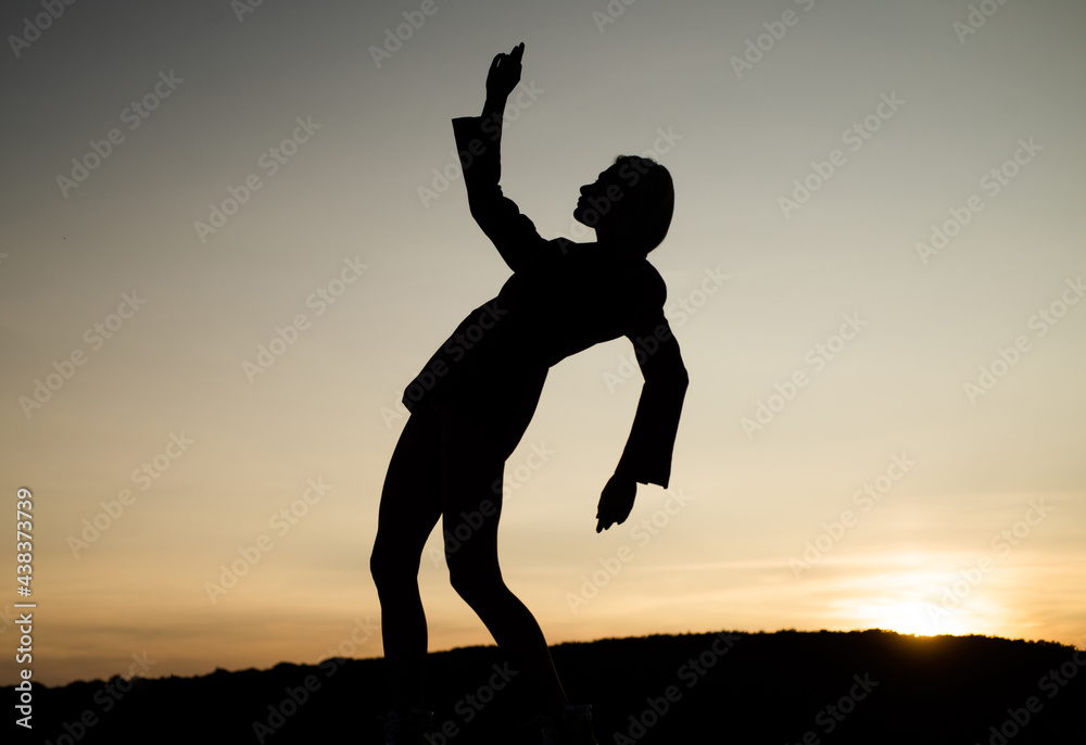 female silhouette on sunset. woman dance in sunrise. dark figure of dancer. dancing in evening female silhouette on sunset. woman dance in sunrise. dark figure of dancer. dancing in evening