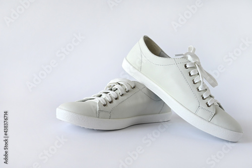 White summer women's sports shoes, stylish leather sneakers isolated on a white background. Advertising fashion shoes. Copy space