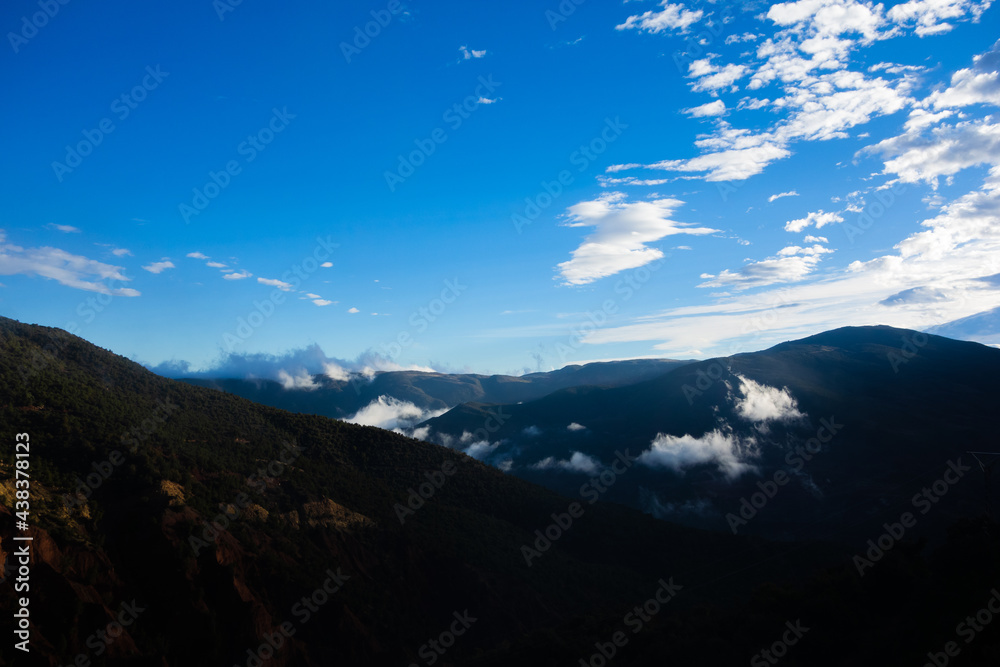 low and high clouds in the High Atlas mountains with blue sky in the background