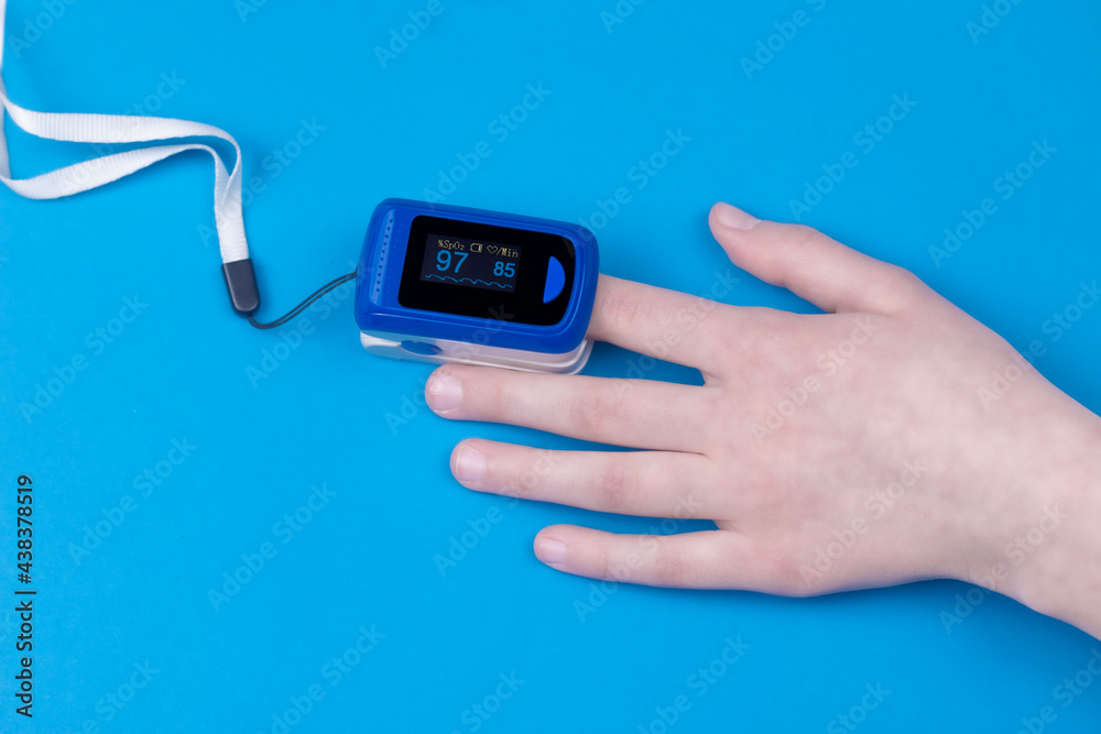 Pulse oximetry on the finger with blue background. Pulse oximetry a