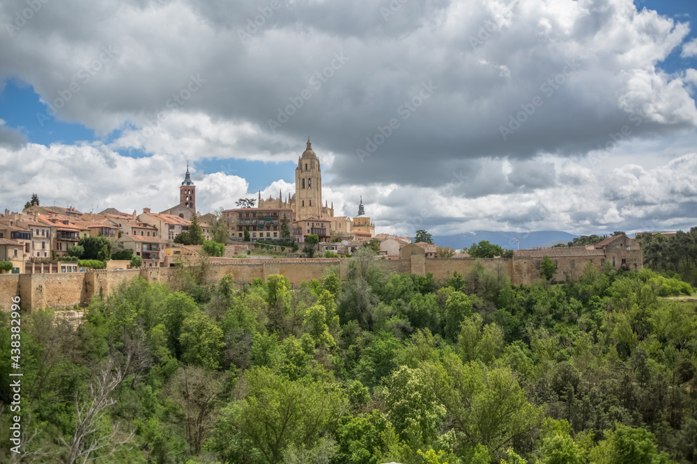 Majestic view at the iconic spanish gothic building at the Segovia cathedral, towers and domes, Segovia fortress and surrounding vegetation