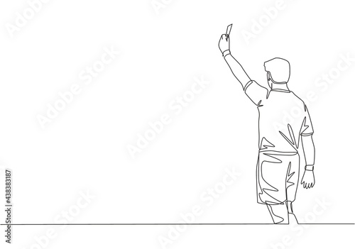 One single line drawing of young referee booked a player yellow card for the foul at the match. Soccer sports concept. Continuous line draw design vector illustration photo