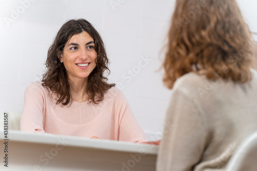 Conversation of two young women in a consultation with a table