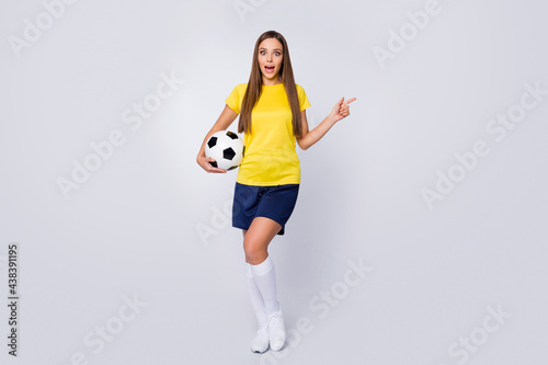 Full length body size view of her she nice beautiful amazed cheerful straight-haired girl holding in hand ball demonstrating ad advert advice isolated over light white gray pastel color background